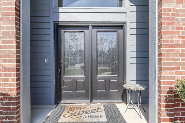 view of exterior entry with brick siding and french doors