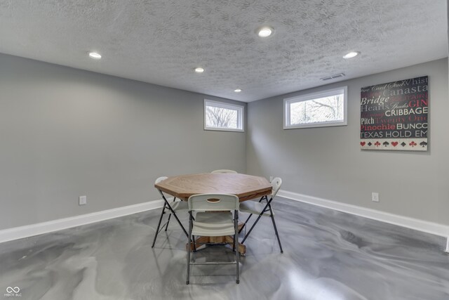 dining room featuring visible vents, baseboards, a textured ceiling, and concrete floors