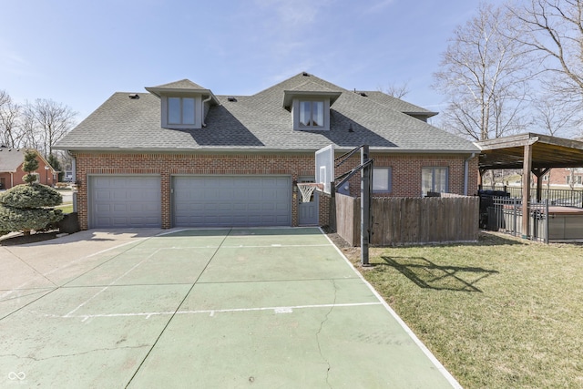 view of front of house with fence, a shingled roof, concrete driveway, a front lawn, and brick siding