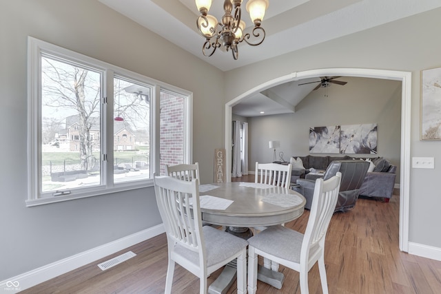 dining space with arched walkways, visible vents, ceiling fan with notable chandelier, and baseboards