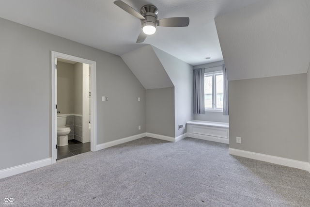 bonus room with baseboards, lofted ceiling, ceiling fan, and carpet floors