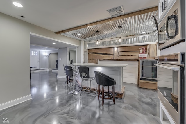 kitchen featuring visible vents, concrete floors, baseboards, arched walkways, and stainless steel appliances