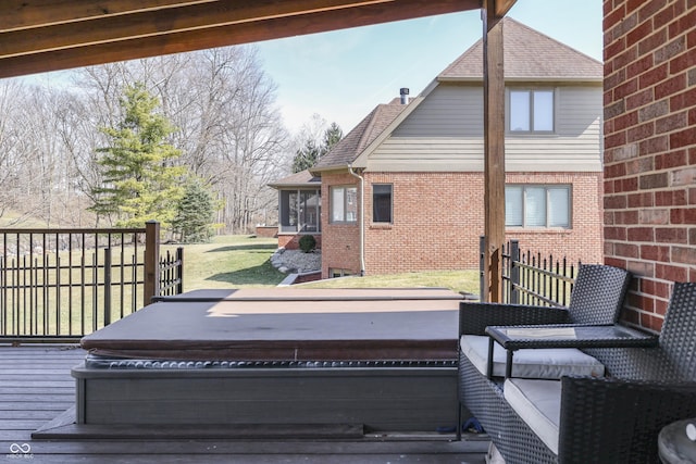 wooden terrace with a yard and a hot tub