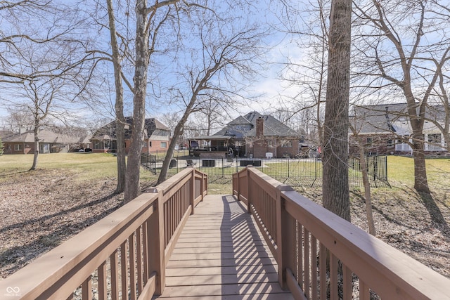 view of community featuring a residential view, a lawn, and fence