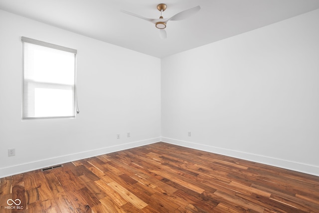 spare room featuring visible vents, baseboards, dark wood-type flooring, and a ceiling fan