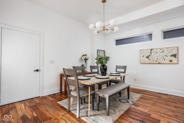 dining room featuring a chandelier, baseboards, and wood finished floors