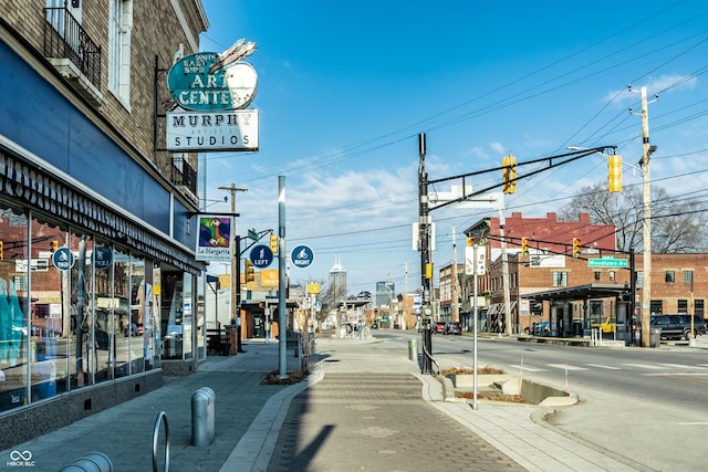 view of road featuring curbs, sidewalks, street lighting, and traffic lights