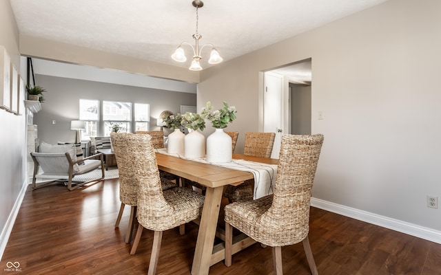 dining area with dark wood-type flooring, baseboards, and a chandelier