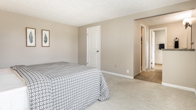 carpeted bedroom featuring a textured ceiling and baseboards