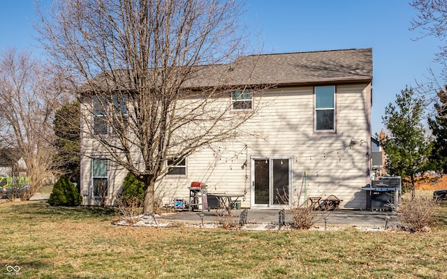 back of property featuring a patio, a lawn, and roof with shingles