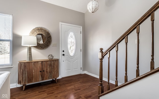 foyer entrance with stairway, plenty of natural light, baseboards, and dark wood-style flooring