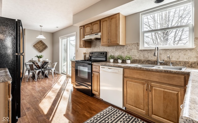 kitchen featuring black appliances, dark wood-style floors, under cabinet range hood, and a sink