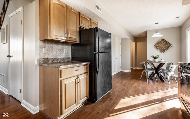 kitchen with dark wood-style floors, visible vents, baseboards, black appliances, and backsplash