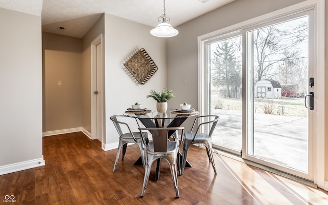 dining area featuring baseboards and wood finished floors