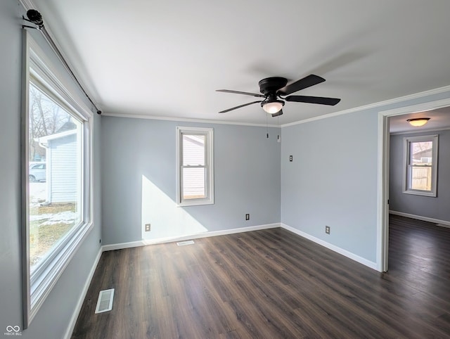 empty room with visible vents, a healthy amount of sunlight, and dark wood-style flooring