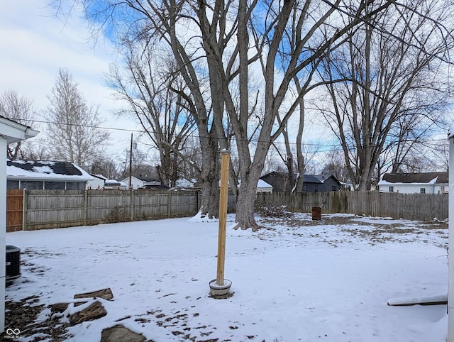 yard layered in snow with a fenced backyard and a residential view