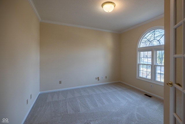 empty room featuring a wealth of natural light, visible vents, ornamental molding, and carpet floors