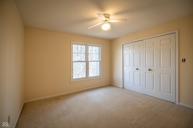 unfurnished bedroom with carpet flooring, a ceiling fan, baseboards, and a closet