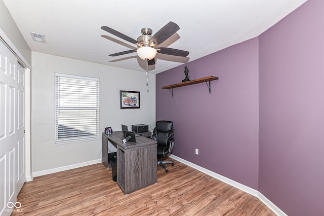 office area featuring a textured ceiling, light wood-style floors, visible vents, and baseboards