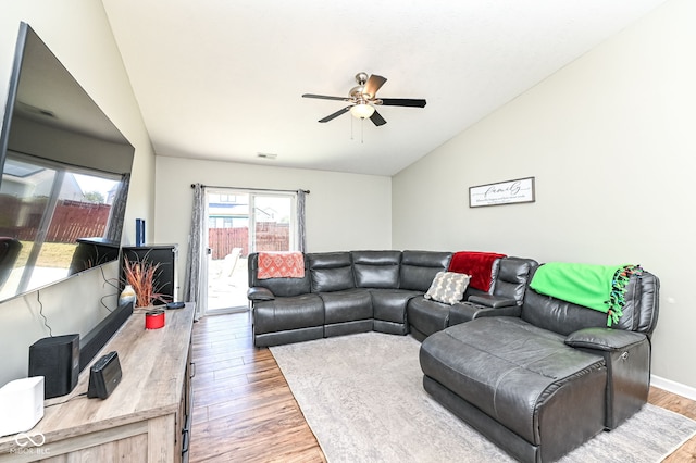 living area featuring ceiling fan, visible vents, wood finished floors, and vaulted ceiling