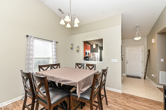 dining room with visible vents, light wood-style flooring, baseboards, and lofted ceiling