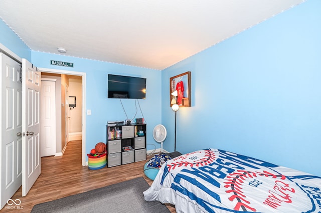 bedroom with baseboards and wood finished floors