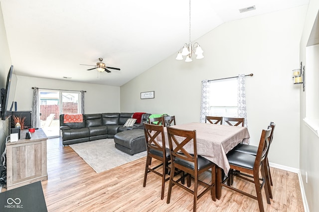 dining room featuring lofted ceiling, ceiling fan with notable chandelier, visible vents, and light wood-type flooring