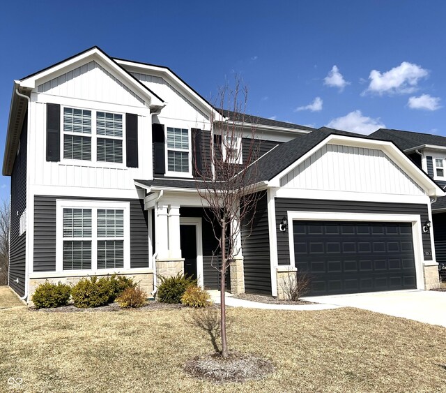 view of front of property with stone siding, board and batten siding, driveway, and a garage