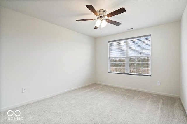 empty room featuring baseboards, visible vents, carpet floors, and ceiling fan