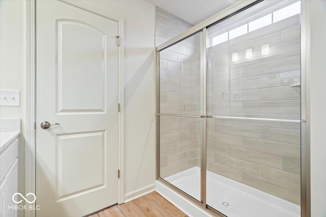 full bath with wood finished floors and a shower stall