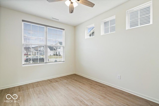 spare room with visible vents, baseboards, wood finished floors, and a ceiling fan