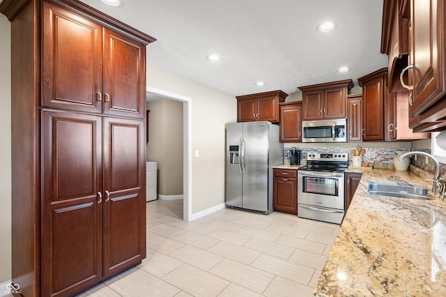 kitchen with light stone countertops, baseboards, recessed lighting, a sink, and stainless steel appliances