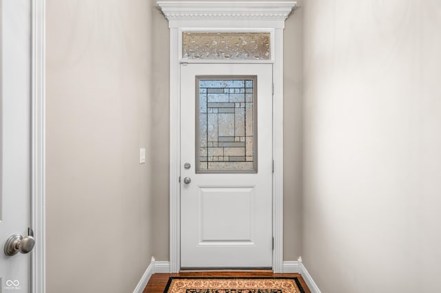 doorway featuring baseboards and dark wood-style flooring