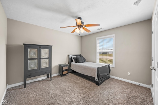 bedroom featuring a ceiling fan, visible vents, baseboards, a textured ceiling, and carpet flooring