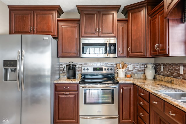 kitchen with backsplash, light stone countertops, and appliances with stainless steel finishes