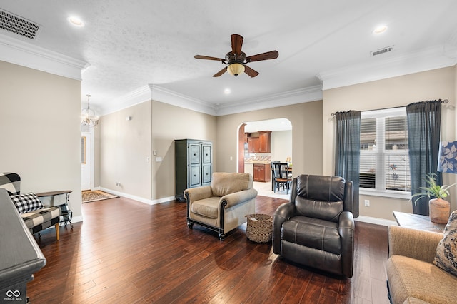 living room featuring visible vents, arched walkways, dark wood-type flooring, and ceiling fan with notable chandelier