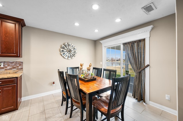 dining room with recessed lighting, visible vents, baseboards, and a textured ceiling