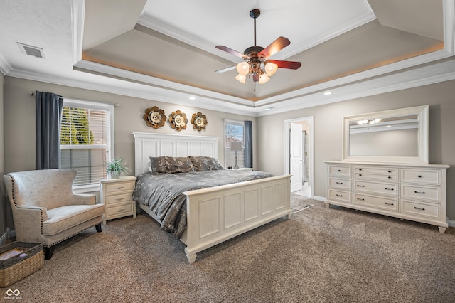 bedroom with visible vents, a tray ceiling, ceiling fan, ornamental molding, and dark colored carpet