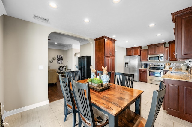 dining space featuring recessed lighting, visible vents, arched walkways, and baseboards