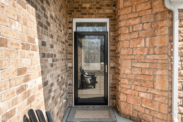 entrance to property featuring brick siding