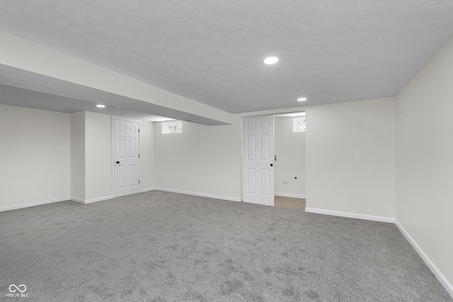 finished basement featuring recessed lighting, baseboards, a textured ceiling, and carpet flooring