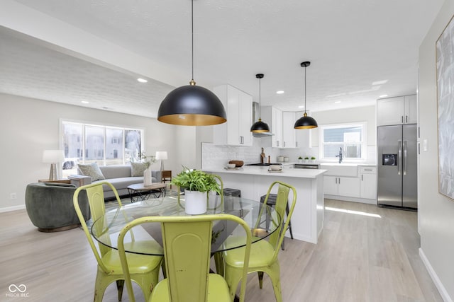 dining space with recessed lighting, light wood-type flooring, and baseboards