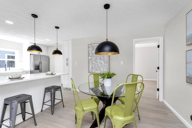 dining space with light wood-style flooring, recessed lighting, and baseboards