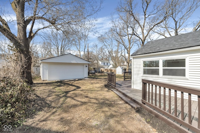 view of yard featuring an outbuilding, a detached garage, and a wooden deck