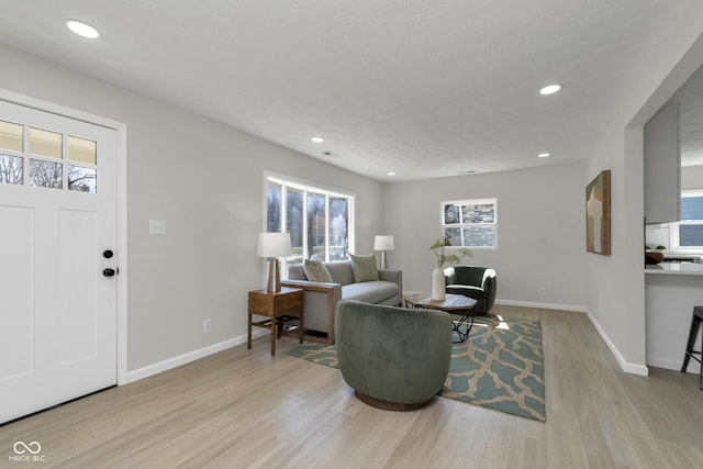 living room featuring plenty of natural light, wood finished floors, recessed lighting, and baseboards