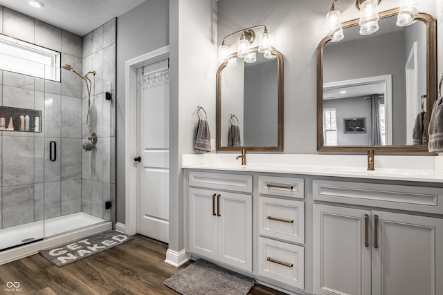 bathroom with a sink, plenty of natural light, wood finished floors, and double vanity