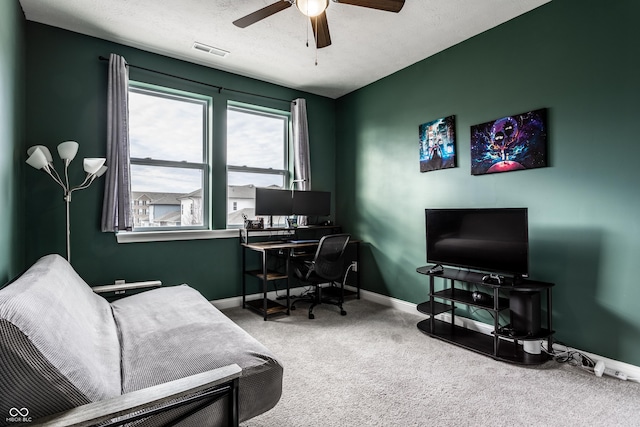 carpeted office featuring visible vents, baseboards, a textured ceiling, and ceiling fan