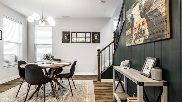 dining room featuring a notable chandelier, visible vents, stairs, and dark wood-style floors