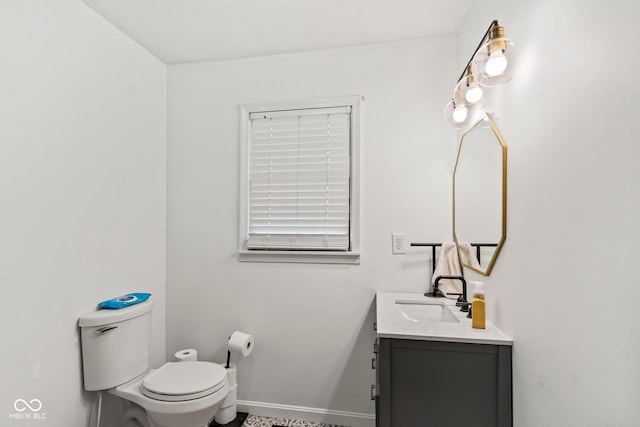 bathroom with baseboards, toilet, and vanity