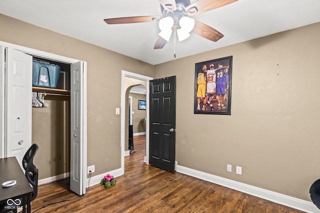 home office with baseboards, arched walkways, and dark wood finished floors